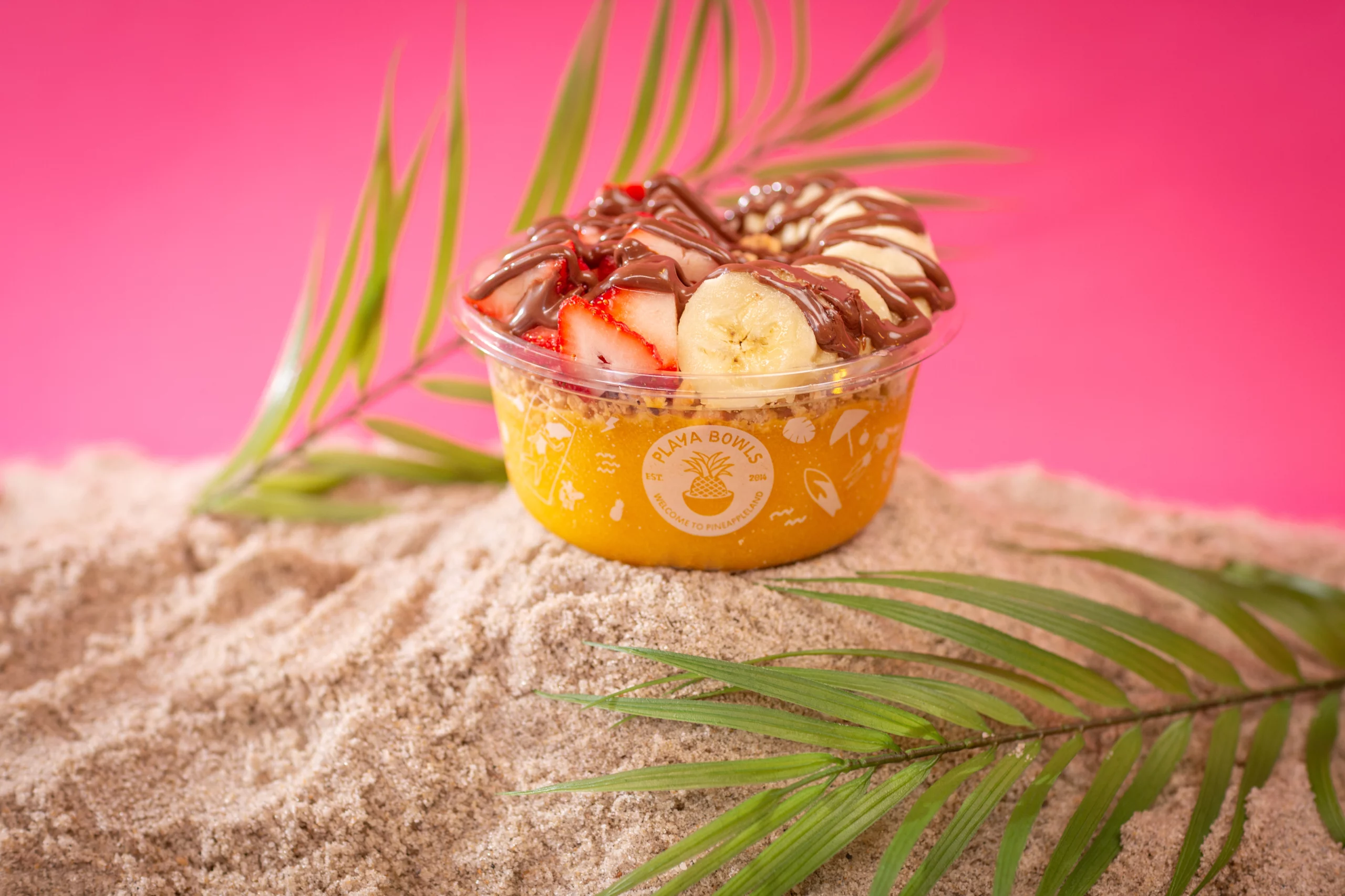 Mango Bowl topped with strawberries, bananas, and a sauce drizzle